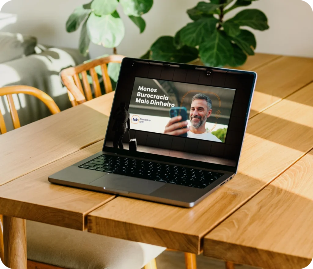 Laptop aberto com texto "Menos Burocracia Mais Dinheiro" na tela